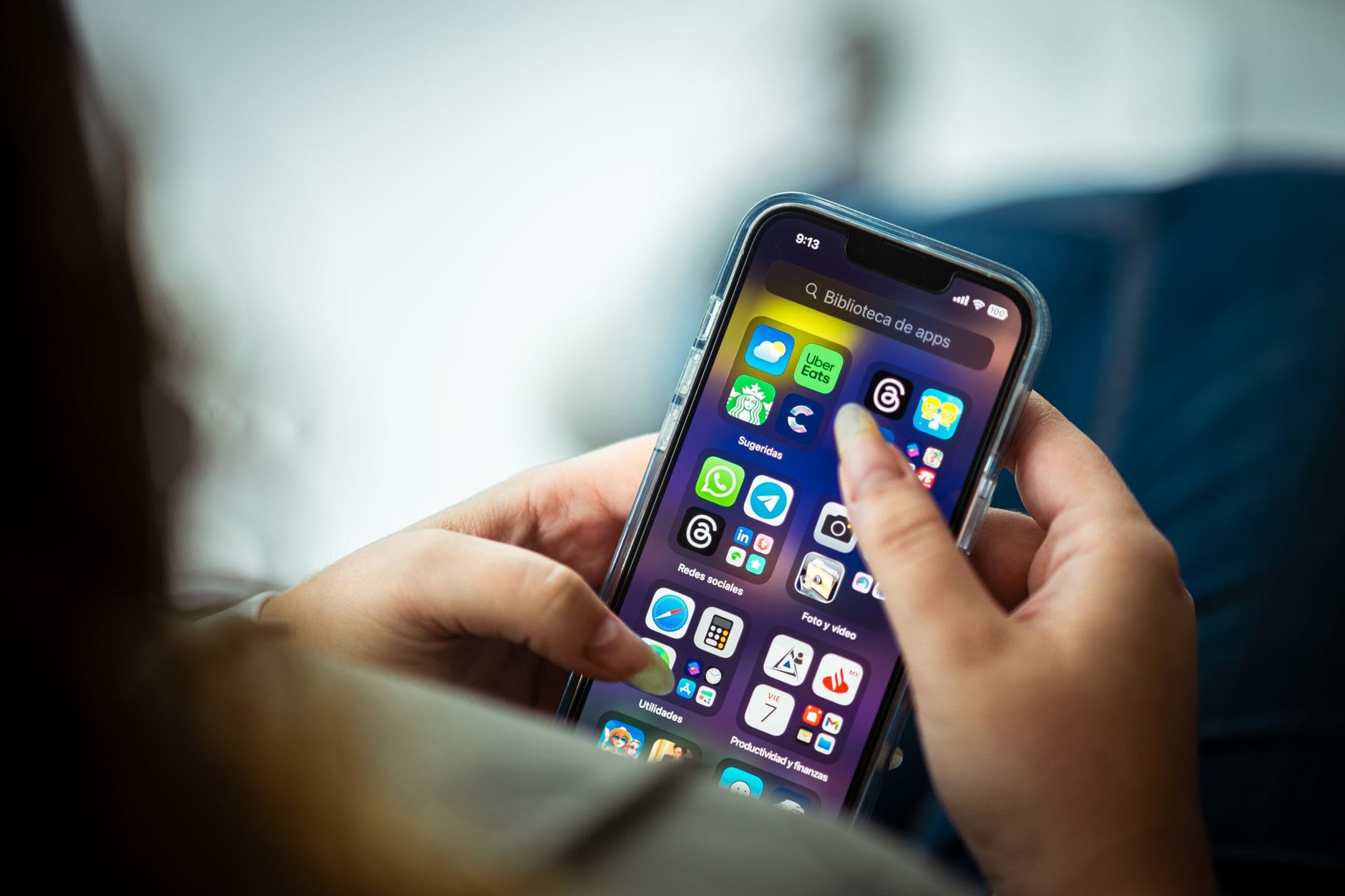 Kobieta trzyma smartfon z kilkoma aplikacjami do rozpoznawania przyrody